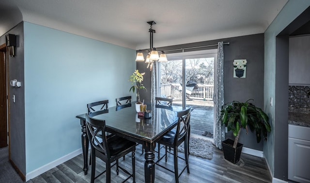 dining area with dark wood-style floors, baseboards, and a chandelier