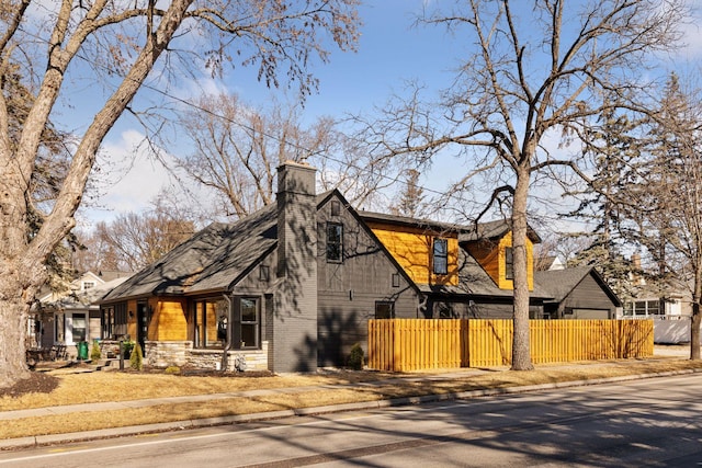 view of front facade with fence and a chimney