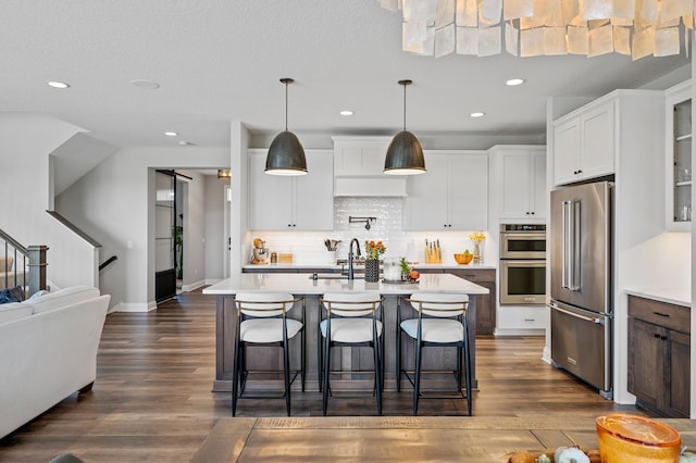 kitchen featuring dark wood finished floors, stainless steel appliances, and light countertops