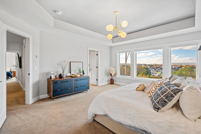 bedroom with baseboards, a chandelier, a raised ceiling, and light colored carpet