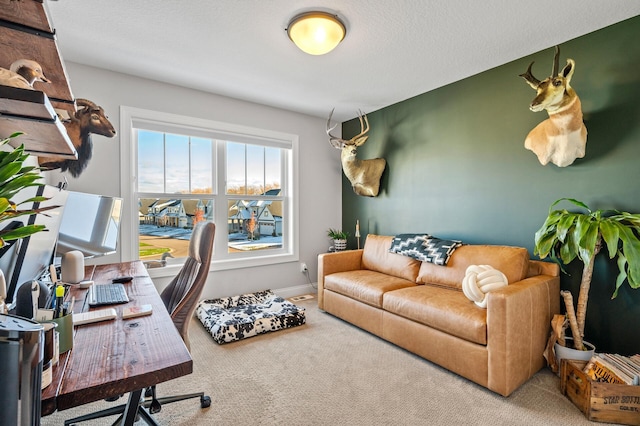 carpeted home office with a textured ceiling and baseboards