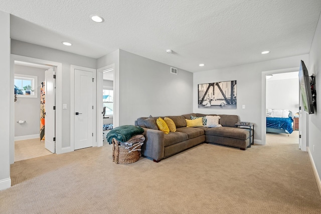 living room featuring plenty of natural light, carpet, visible vents, and recessed lighting