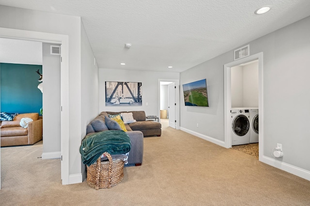 carpeted living area with recessed lighting, visible vents, baseboards, and separate washer and dryer