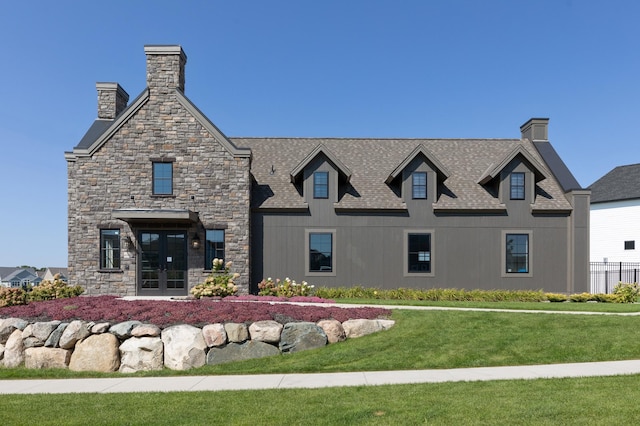 view of front of house featuring french doors, a chimney, and a front lawn