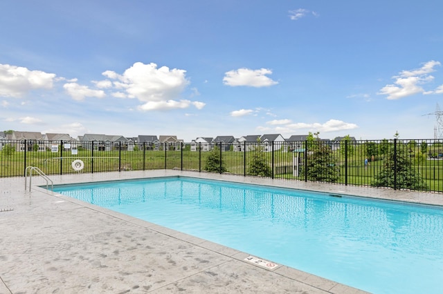 community pool with fence and a residential view