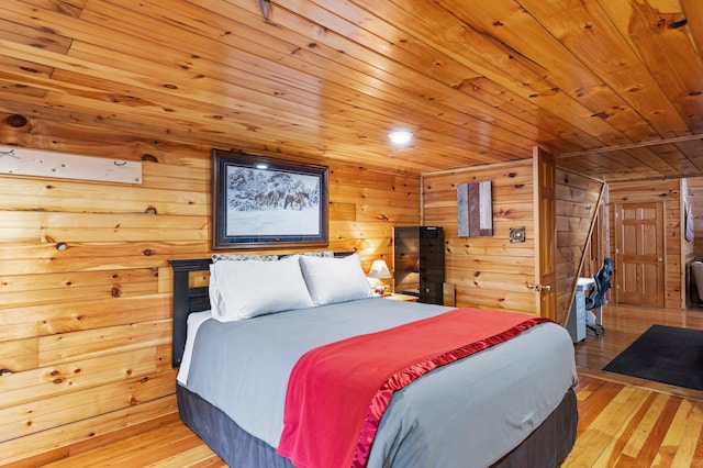 bedroom with wooden ceiling, light wood-style flooring, and wood walls