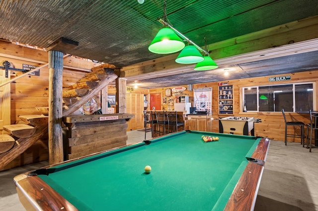 game room with concrete floors, billiards, wooden walls, and a bar
