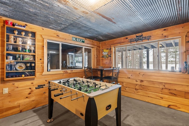 game room featuring wooden ceiling, concrete floors, and wooden walls