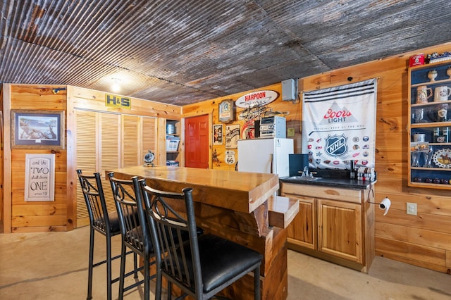 bar featuring wooden ceiling and wooden walls