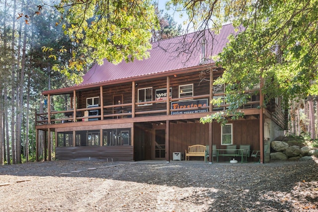 back of property featuring metal roof and log siding