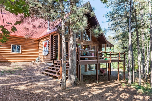 rear view of house with a deck, metal roof, log exterior, and stairs