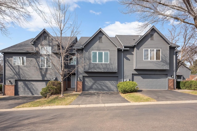 view of front of house featuring brick siding, driveway, and a garage