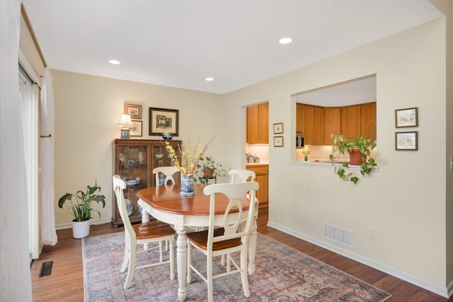 dining area with light wood-style flooring, baseboards, and visible vents