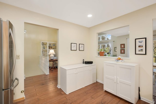 bar with freestanding refrigerator, light wood finished floors, and recessed lighting