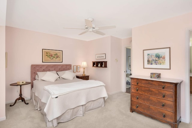 bedroom featuring light colored carpet, baseboards, and a ceiling fan