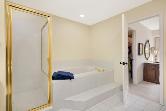 full bath featuring a stall shower, baseboards, a bath, and tile patterned floors