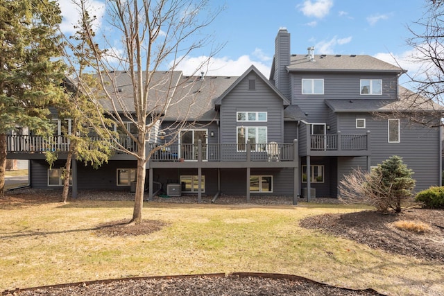 back of house featuring a yard, a chimney, a deck, and central AC