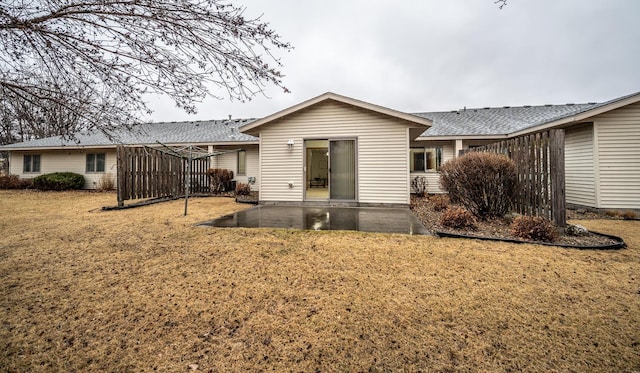 rear view of property featuring a patio and a lawn