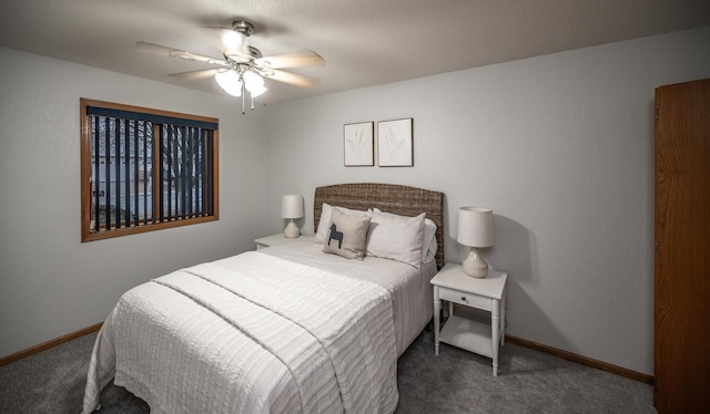 carpeted bedroom featuring a textured wall, a ceiling fan, and baseboards