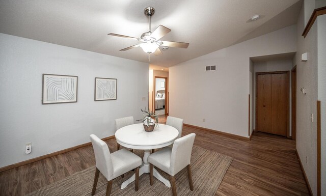 dining room with a ceiling fan, baseboards, visible vents, and wood finished floors