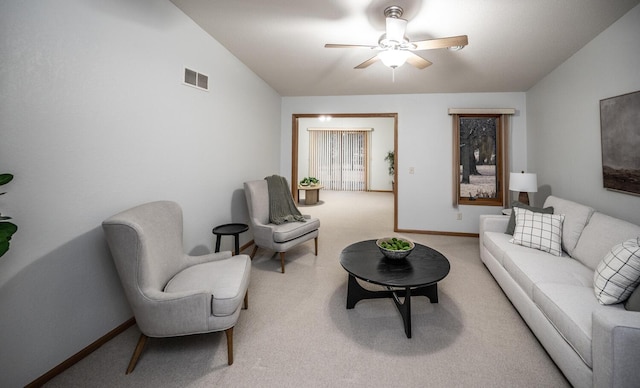 carpeted living room with ceiling fan, vaulted ceiling, visible vents, and baseboards