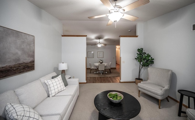 carpeted living room featuring ceiling fan, visible vents, and baseboards