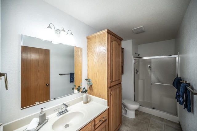 bathroom with toilet, visible vents, vanity, tile patterned floors, and a stall shower