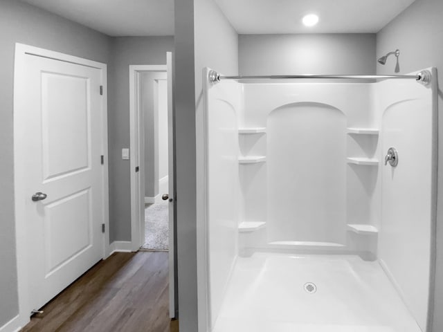 full bathroom featuring walk in shower and wood finished floors