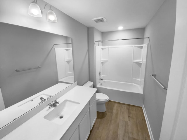 full bath with bathing tub / shower combination, visible vents, toilet, vanity, and wood finished floors