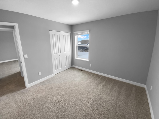 unfurnished bedroom featuring a closet, carpet, and baseboards