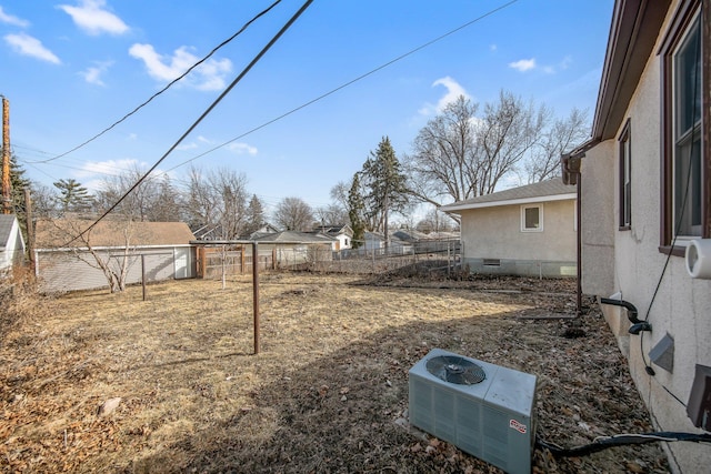 view of yard with central AC and fence