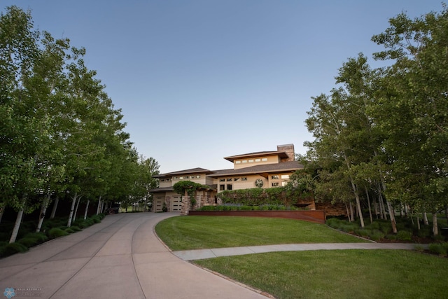 view of front facade with driveway, a garage, and a front lawn