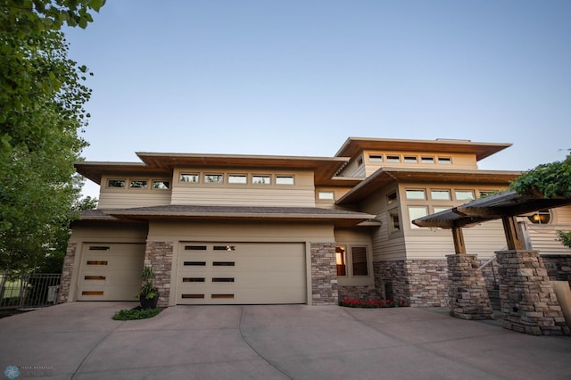 prairie-style house featuring concrete driveway and an attached garage