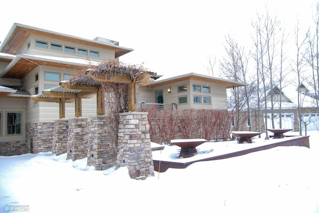 view of snow covered back of property