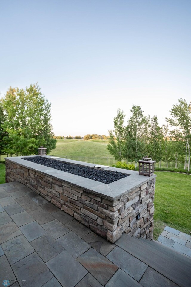 view of patio featuring an outdoor fire pit and fence