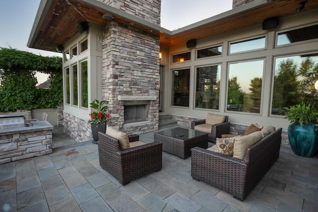 view of patio / terrace featuring an outdoor living space with a fireplace and an outdoor kitchen