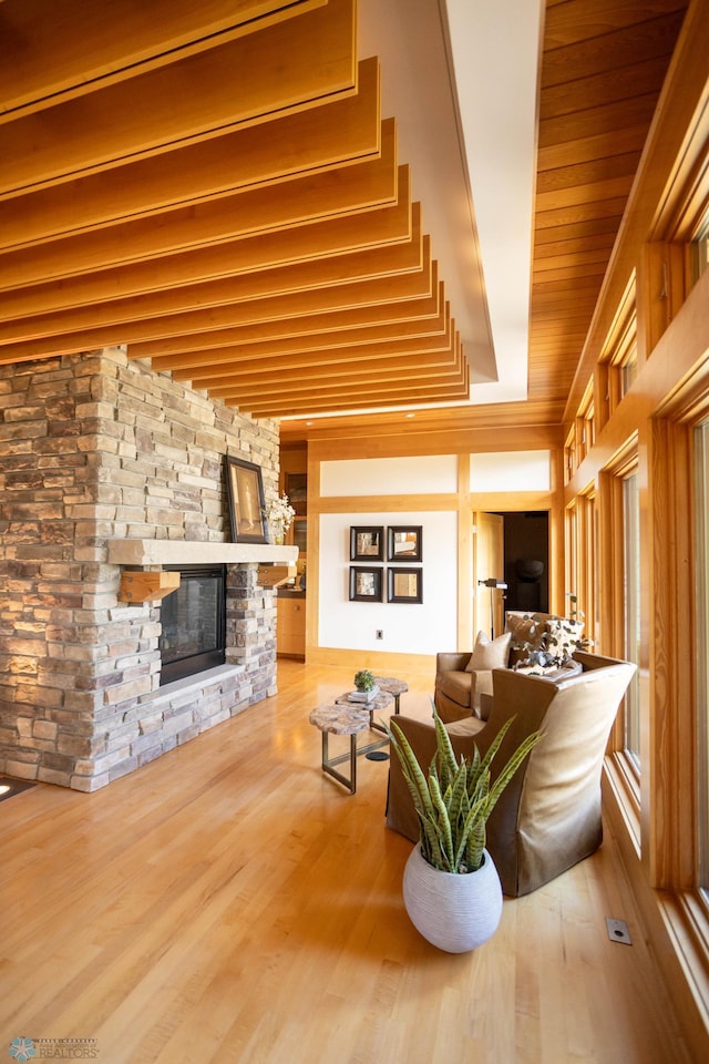 living area featuring wood ceiling, a fireplace, and wood finished floors
