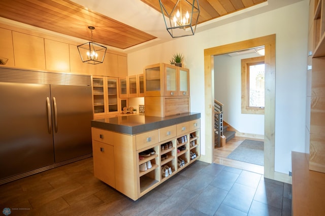 kitchen with open shelves, glass insert cabinets, stainless steel built in refrigerator, and a notable chandelier