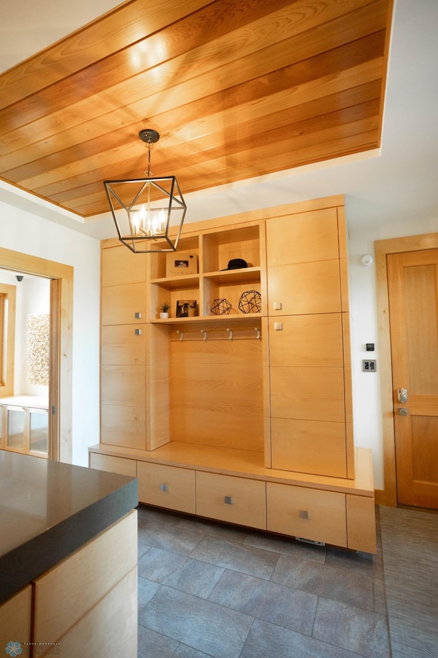 mudroom featuring an inviting chandelier and wood ceiling
