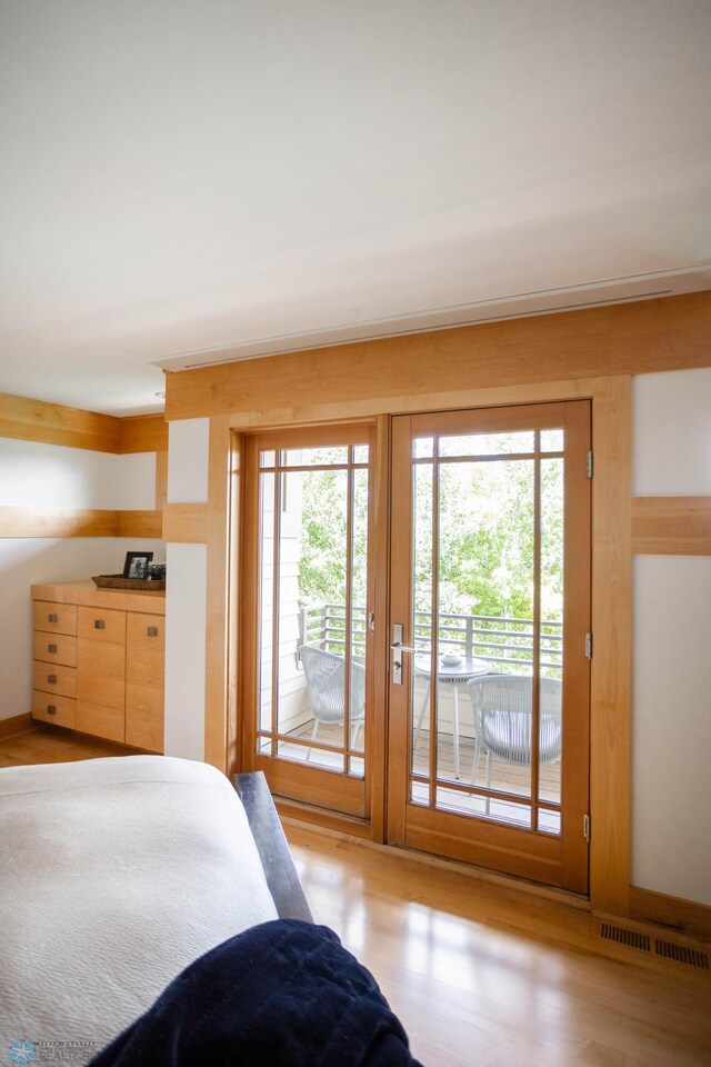 bedroom with access to outside, light wood-style flooring, and visible vents