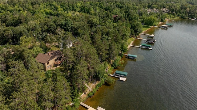 drone / aerial view with a forest view and a water view