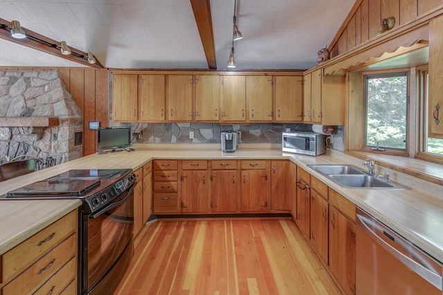 kitchen with stainless steel appliances, brown cabinets, light countertops, and a sink