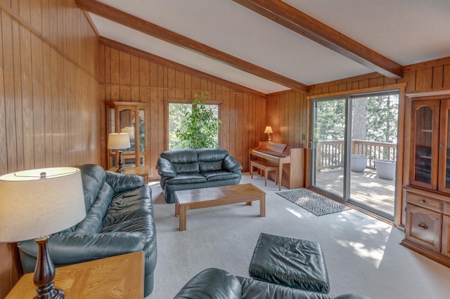 living area with lofted ceiling with beams, light carpet, and wooden walls