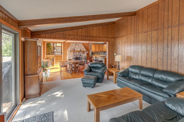 living area featuring vaulted ceiling with beams, light wood-style flooring, and wooden walls