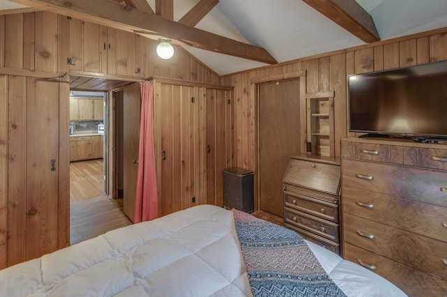 bedroom featuring wooden walls, light wood-type flooring, and lofted ceiling with beams