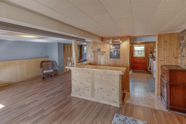 kitchen with wood walls and wood finished floors