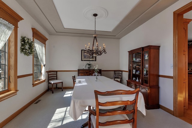 617 17th St N, Sartell, MN 56377 - carpeted dining room with a chandelier, baseboards, and a raised ceiling