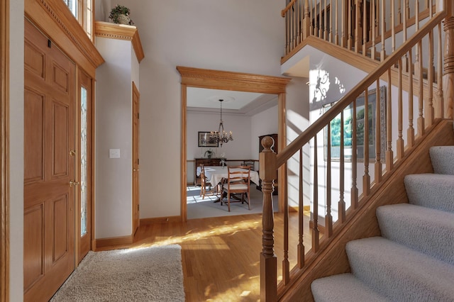 617 17th St N, Sartell, MN 56377 - foyer featuring a high ceiling, stairs, wood finished floors, a chandelier, and baseboards