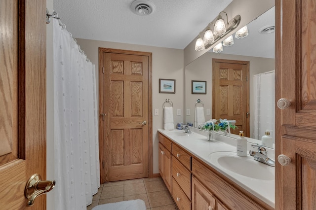 617 17th St N, Sartell, MN 56377 - bathroom with double vanity, tile patterned floors, and a textured ceiling