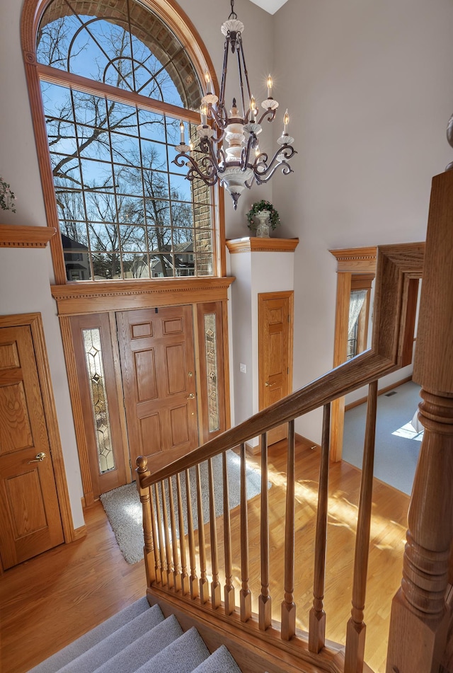 617 17th St N, Sartell, MN 56377 - entryway featuring a high ceiling, light wood finished floors, a chandelier, and stairs